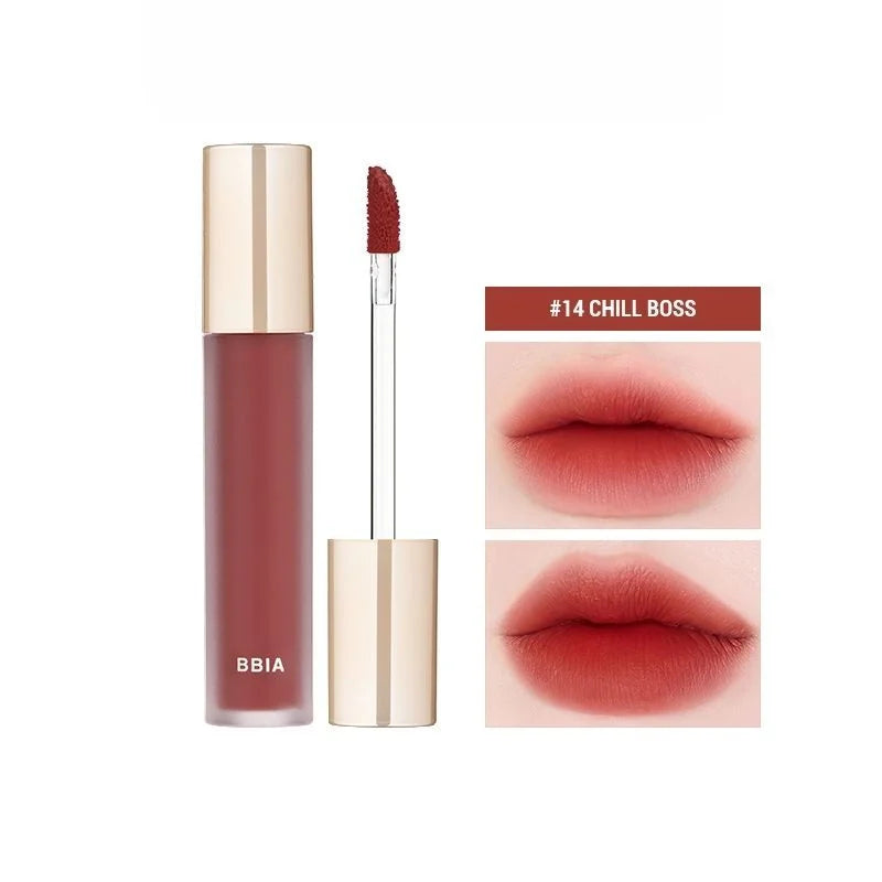 A tube of BBIA LAST VELVET TINE with a rose gold cap, shown with its applicator wand and a swatch of lipstick color behind it. Buy at MyAllures for the perfect touch of glamour.