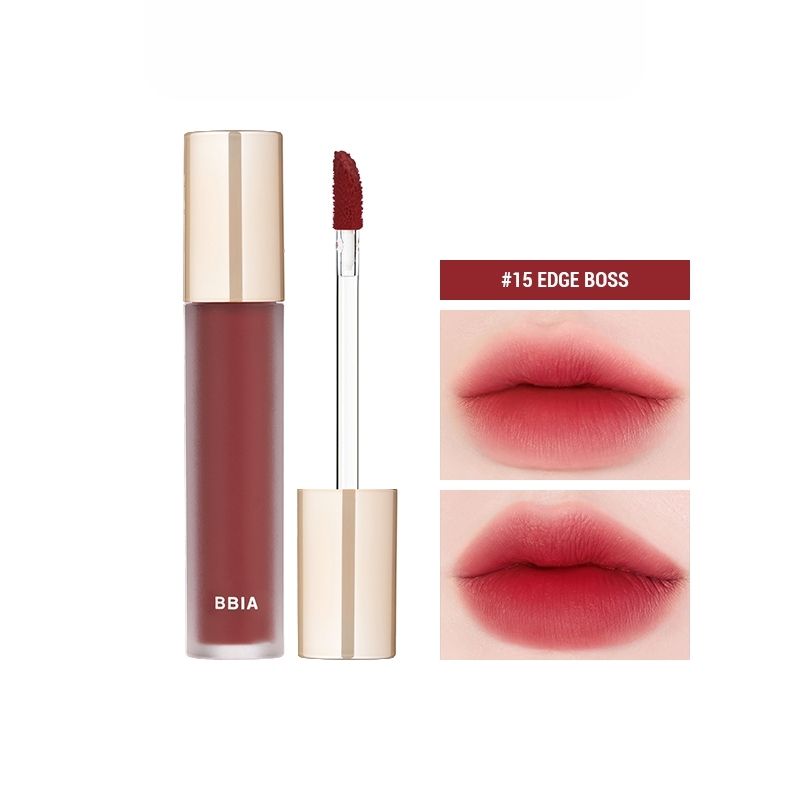 A tube of BBIA LAST VELVET TINE in a striking red shade, featuring a gold cap, is depicted alongside an open applicator wand and a swatch of the rich lipstick color in the background. Purchase this elegant addition to your makeup collection at MyAllures.