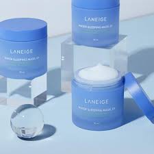 A jar of LANEIGE WATER SLEEPING MASK with the lid off, showcasing the product's creamy texture. The blue-toned background features water droplets, highlighting the product's hydrating properties. Buy at MyAllures for a rejuvenating skincare experience.