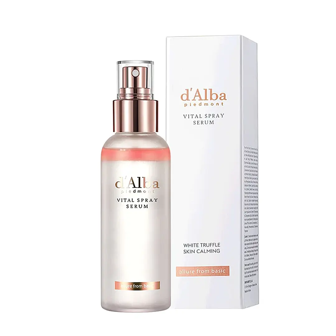 A translucent bottle of DALBA VITAL SPRAY SERUM with a metallic cap is placed next to its white rectangular box packaging. The label mentions "White Truffle" and "Skin Calming." Available to buy at MyAllures.


